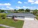 Beautiful single-story home featuring an attached three-car garage, landscaped yard, and waterfront views at 2309 Conway Blvd, Port Charlotte, FL 33952