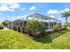 A screened pool with surrounding greenery offers privacy and a tranquil outdoor space for relaxation and recreation at 2309 Conway Blvd, Port Charlotte, FL 33952