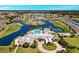Aerial view of the community's clubhouse, pool, tennis courts, and surrounding residences at 24132 Buckingham Way, Punta Gorda, FL 33980
