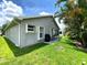 Well-maintained backyard with lush green grass, patio area, and privacy provided by mature palm trees at 24132 Buckingham Way, Punta Gorda, FL 33980
