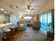 Living room featuring hardwood floors, comfortable sofas, ceiling fan, and open floorplan at 24132 Buckingham Way, Punta Gorda, FL 33980