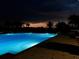 Exterior illuminated view of the resident pool at night with nearby trees and shrubs at 24132 Buckingham Way, Punta Gorda, FL 33980
