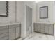 Modern bathroom featuring double vanity, gray cabinets, textured white tile and a marble floor at 24317 Treasure Island Blvd, Punta Gorda, FL 33955