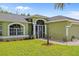 Charming home with well-manicured lawn, arched windows, and decorative front door. Garage on right at 2455 Jacoby Cir, North Port, FL 34288