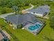 An aerial view of a well maintained home and yard, with a screened-in pool with furniture at 2455 Jacoby Cir, North Port, FL 34288