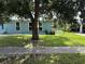 A cozy one-story home with well-kept lawn, shadowed by a mature tree at 2513 Ambrose Ln, Port Charlotte, FL 33952