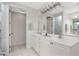 Bright bathroom features double vanity, white cabinets, and marble-look shower at 2630 Tarpon Cove Dr # 211, Punta Gorda, FL 33950