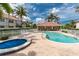 Community pool area with palm trees, lounge chairs, and a hot tub at 2630 Tarpon Cove Dr # 211, Punta Gorda, FL 33950