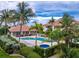 Lushly landscaped community pool area, featuring a hot tub, palm trees, and a clubhouse at 2630 Tarpon Cove Dr # 211, Punta Gorda, FL 33950