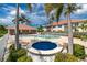 Inviting community pool with a hot tub, surrounded by lush landscaping and palm trees at 2630 Tarpon Cove Dr # 211, Punta Gorda, FL 33950