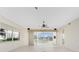 Bright, empty living room with tile floors, large windows, and a ceiling fan perfect for relaxation at 2630 Tarpon Cove Dr # 211, Punta Gorda, FL 33950
