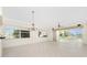 Spacious living room with tile flooring, natural light, and a modern chandelier for elegant living at 2630 Tarpon Cove Dr # 211, Punta Gorda, FL 33950