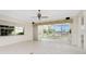 Empty living room featuring tile floors, a ceiling fan, and expansive windows for bright, airy living at 2630 Tarpon Cove Dr # 211, Punta Gorda, FL 33950