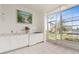 Wet bar and tiled lanai area with modern appliances and waterfront views through expansive windows at 2630 Tarpon Cove Dr # 211, Punta Gorda, FL 33950