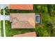 An aerial view shows the home's layout and screened pool amongst manicured landscaping and grass at 2712 Arugula Dr, North Port, FL 34289