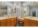 Bright bathroom featuring double vanity, framed mirrors, and glass shower with decorative tile accents at 2712 Arugula Dr, North Port, FL 34289