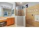 Bright bathroom featuring double vanity, framed mirrors, and glass shower with decorative tile accents at 2712 Arugula Dr, North Port, FL 34289