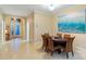 Elegant dining room with a round table, wicker chairs, and artwork evoking a coastal theme at 2712 Arugula Dr, North Port, FL 34289