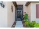 Close-up of the home's front entrance, featuring a secure screen door, and decorative plants at 2712 Arugula Dr, North Port, FL 34289