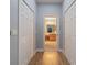Hallway with wood floors and closet space leads to a bathroom at 2712 Arugula Dr, North Port, FL 34289