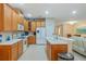 Open kitchen features tile floors, stainless steel appliances, and wood cabinets at 2712 Arugula Dr, North Port, FL 34289
