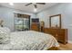 Main bedroom featuring wood floors, ceiling fan, and lanai access at 2712 Arugula Dr, North Port, FL 34289