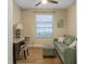 Bright home office featuring a comfortable green sofa and workspace with natural light from a window at 2712 Arugula Dr, North Port, FL 34289