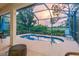 Inviting screened lanai with a pool, outdoor seating, and serene landscaping at 2712 Arugula Dr, North Port, FL 34289