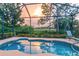 Inviting screened lanai with a pool, outdoor seating, and serene landscaping at 2712 Arugula Dr, North Port, FL 34289