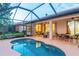 A kidney shaped pool sits on a screened in porch with outdoor seating and access to the home's interior at 2712 Arugula Dr, North Port, FL 34289