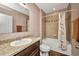 Cozy bathroom with tub-shower combo, vanity with granite countertop, and warm neutral tones at 27896 Arrowhead Cir, Punta Gorda, FL 33982