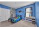 Bright blue bedroom featuring a fun accent wall, carpeted floors, and a window at 27896 Arrowhead Cir, Punta Gorda, FL 33982