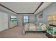 Inviting bedroom with carpet flooring, a tray ceiling, and warm natural lighting at 27896 Arrowhead Cir, Punta Gorda, FL 33982