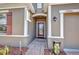 Inviting entrance with brick pathway, glass paneled door, and decorative floral arrangement at 27896 Arrowhead Cir, Punta Gorda, FL 33982