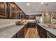 View of kitchen showcasing dark cabinets, stainless steel appliances, and granite countertops at 27896 Arrowhead Cir, Punta Gorda, FL 33982