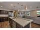 Kitchen open to living area features dark cabinets, stainless steel refrigerator, and granite countertops at 27896 Arrowhead Cir, Punta Gorda, FL 33982