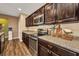 Close-up of kitchen featuring dark cabinets, stainless steel appliances, and granite countertops at 27896 Arrowhead Cir, Punta Gorda, FL 33982