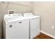 Laundry area with washer and dryer, white cabinets, and neutral walls at 27896 Arrowhead Cir, Punta Gorda, FL 33982