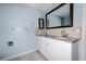 Bathroom with granite counters, double sinks, light tile flooring, and a large, framed mirror at 3085 Arrowhead Rd, Venice, FL 34293