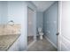 Bathroom featuring a granite countertop, white cabinets, and a tiled shower at 3085 Arrowhead Rd, Venice, FL 34293
