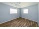 Bright bedroom featuring wood floors, a ceiling fan and two windows at 3085 Arrowhead Rd, Venice, FL 34293