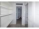 Bright and spacious closet with open shelving leads to ensuite bathroom at 3085 Arrowhead Rd, Venice, FL 34293