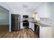 Modern kitchen featuring stainless steel appliances, granite countertops, white cabinetry, and stylish backsplash at 3085 Arrowhead Rd, Venice, FL 34293