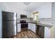 Modern kitchen featuring stainless steel appliances, granite countertops, white cabinetry, and stylish backsplash at 3085 Arrowhead Rd, Venice, FL 34293