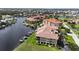 Waterfront condo building on canal with boat docks and lush landscaping, with views of the Gulf of Mexico in background at 3308 Purple Martin Dr # 121, Punta Gorda, FL 33950