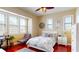 Bright bedroom has a ceiling fan, bed, windows with blinds, and sleek red wood flooring at 3308 Purple Martin Dr # 121, Punta Gorda, FL 33950