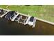 Boat docks featuring lifts in canal with manicured lawn behind them at 3308 Purple Martin Dr # 121, Punta Gorda, FL 33950