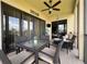 Screened patio has dining set, ceiling fan, views of lake and the outside through glass sliding doors at 3308 Purple Martin Dr # 121, Punta Gorda, FL 33950