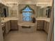 Bright bathroom features a tub under a window, double sinks and neutral tile flooring at 388 Orlando Blvd, Port Charlotte, FL 33954