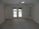 The main bedroom has pool access through French doors and a bright window with carpeting and a ceiling fan at 388 Orlando Blvd, Port Charlotte, FL 33954